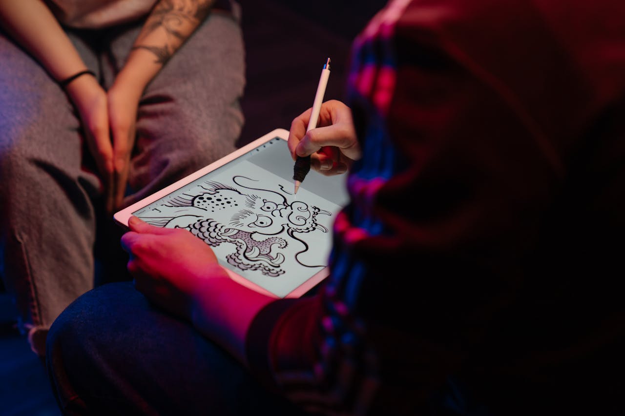 Artist creating a digital dragon tattoo design on tablet, emphasizing neon glow and creativity.